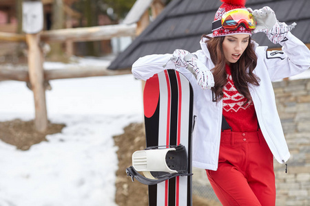 女子滑雪板与滑雪板站在冬季度假村