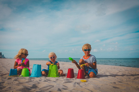 快乐的孩子玩玩具和沙滩在海滩度假