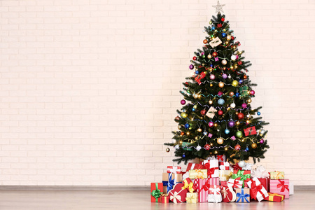 有装饰的圣诞树盒的圣诞树砖墙背景