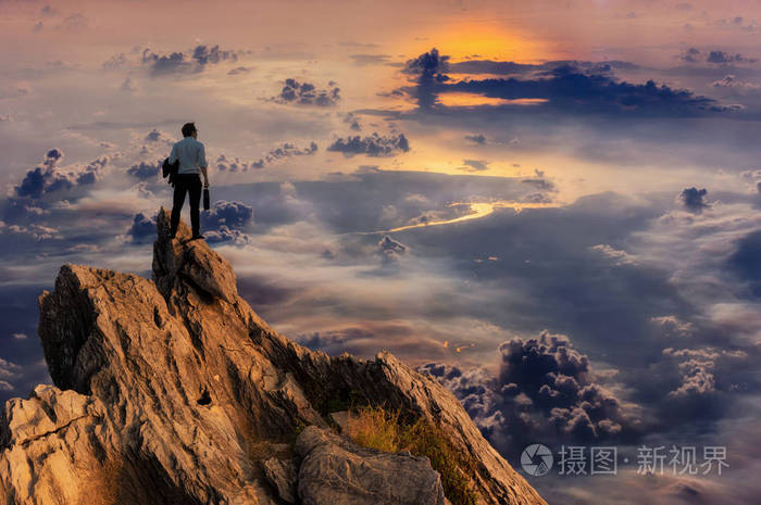 概念视觉年轻商人穿着舒适的休闲西装外套,站在山顶,期待成功的竞争和