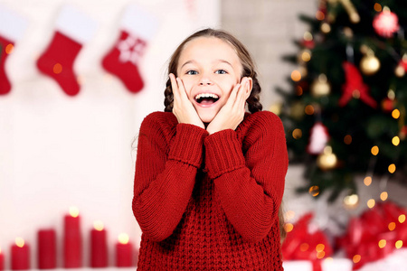 家附近圣诞树旁穿红毛衣的年轻女孩