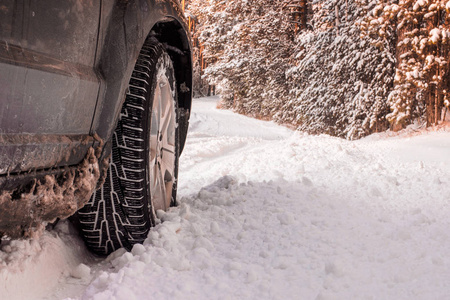 冬天道路上的汽车轮胎覆盖着雪。 早上下雪时，雪巷上的车辆。
