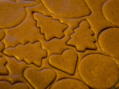 自制姜饼饼干和烘焙原料。 姜饼的形状是人和其他形状。 圣诞节和汉努卡期间厨房的场景。 近距离拍摄正在制作的食物。