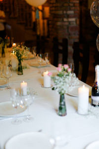 桌上的花白盘子和蜡烛的 Bouguet