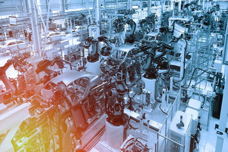 组装汽车机器人的零件.汽车的自动化制造过程.工厂生产蓝色汽车.