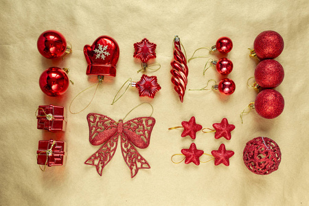 圣诞节平躺着金色和红色闪亮的玩具和珠子在纸的背景上。 上面的风景。