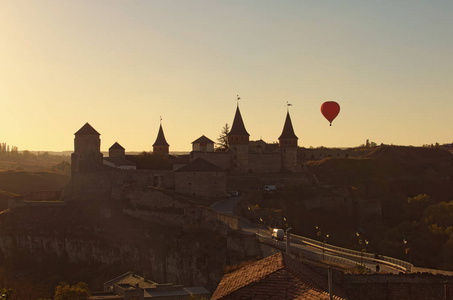 热气球飞近卡米涅茨波迪尔斯基城堡。 它是著名的旅游场所和浪漫的旅游目的地。 美丽的秋天日落景观。 乌克兰Kamenetzpodo