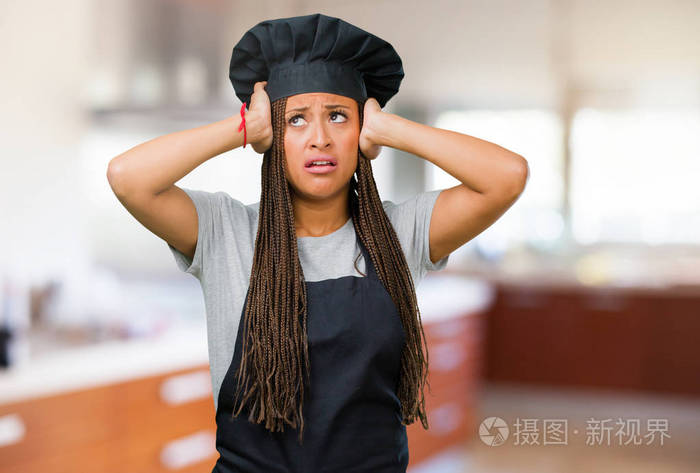 一位年轻的黑人面包师的肖像，一位担心和不知所措的健忘的女人意识到了某种震惊的表情，因为她犯了一个错误
