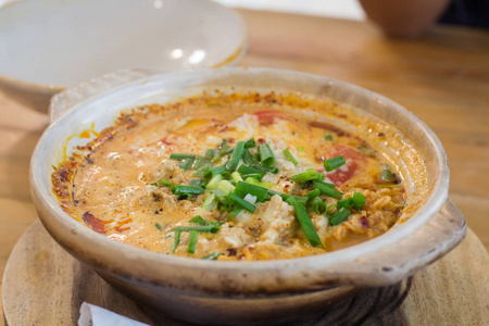 汤姆尤姆功夫与面条和海鲜流行泰国菜。 TomYumGoong辣酸汤木桌上观看泰国当地食物
