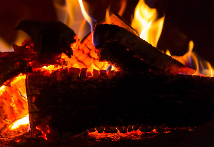 火焰，橙色，红色，热木，关闭背景，篝火在黑暗的煤，明亮的壁炉基础设计。