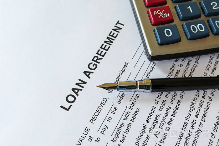 商业贷款协议或法律文件概念。 钢笔和计算器的贷款协议纸质表格。 贷款协议是借款人与贷款人之间的合同。