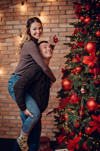 年轻夫妇打扮圣诞树在家里