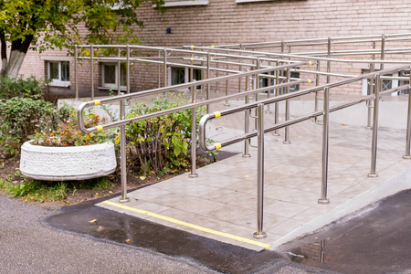 与不锈钢扶手与残疾人标志的混凝土坡道方式支持轮椅残疾人.医疗理念.