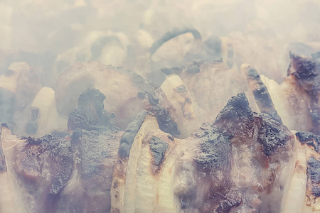 烤架上的肉在烟雾中，特写