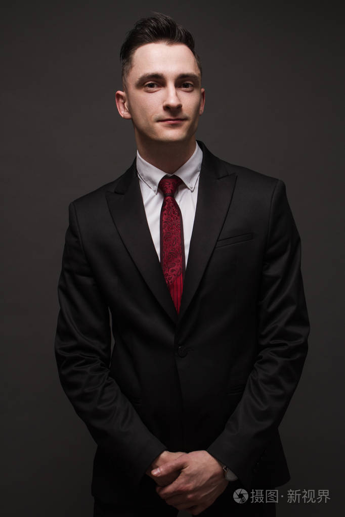 穿着优雅西装的年轻人摆姿势.商业风格.男性美,时尚.发型.