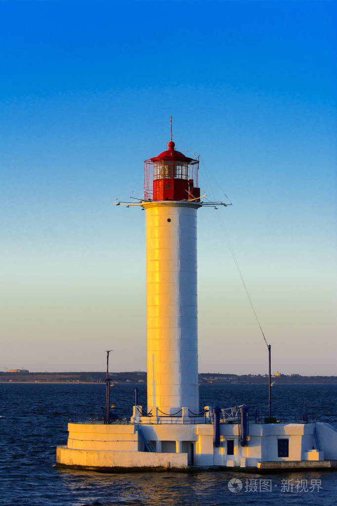 港口入口处的一个灯塔,背景是一个美丽的傍晚,蓝色的天空,柔和的颜色