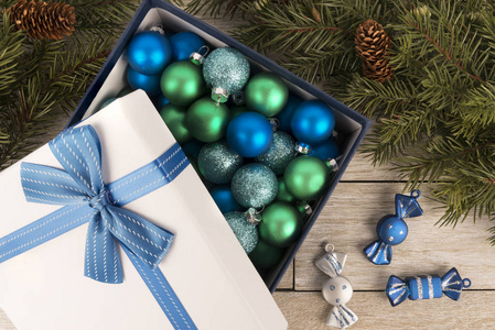 圣诞彩带装饰在礼品盒与丝带和蝴蝶结。 平躺着。 白色木制背景。