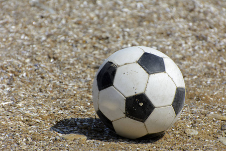 皮革足球位于沙滩的背景上。 摄影棚拍摄。 复制空间。 海滩特写足球的概念。 运动队比赛。