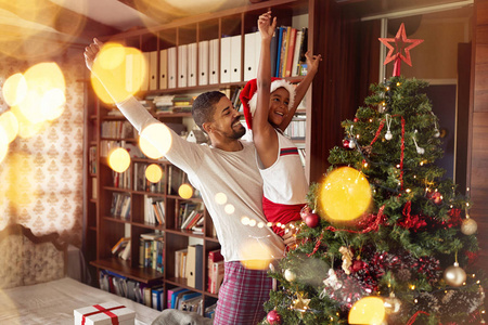可爱的非裔美国女孩和快乐的父亲一起玩和装饰圣诞树
