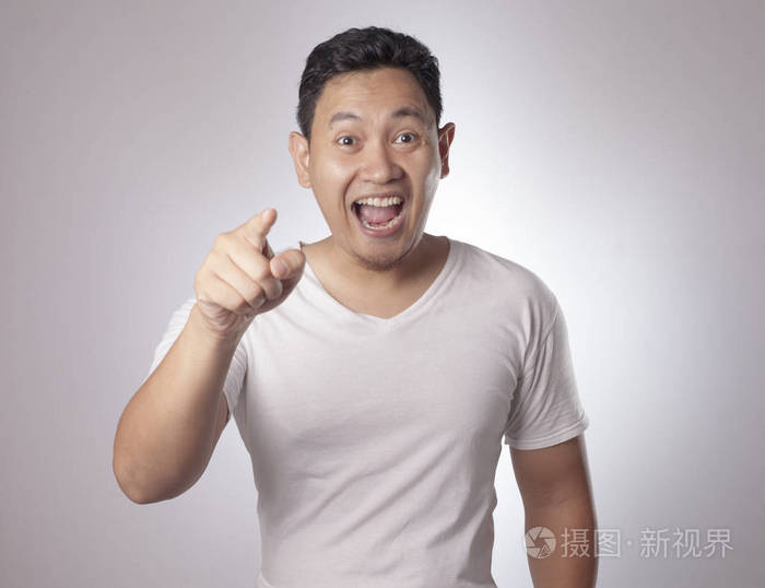 亚洲年轻人的肖像,指着前方看着相机. 选择一个概念