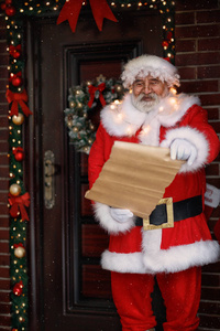 圣诞老人在门前念着孩子们的愿望清单