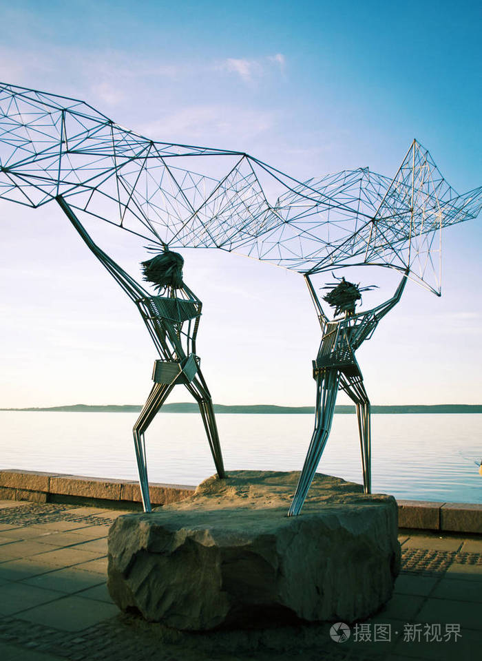 海滨渔民的雕塑在海里扔一张网