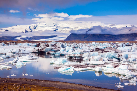 白色的蓝色冰堆在泻湖的绿松石水中。 漂流冰湖Jokulsarlon。 冰岛的独特性质