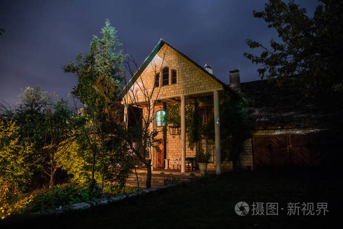 夜晚用月亮在森林中建造的山景或夜晚用云彩和星星建造的老式乡村房子