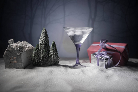 冬季鸡尾酒酒精饮料和雪景与圣诞节主题或想法和食谱的圣诞饮料。 雪地上的马提尼杯和圣诞装饰复制空间