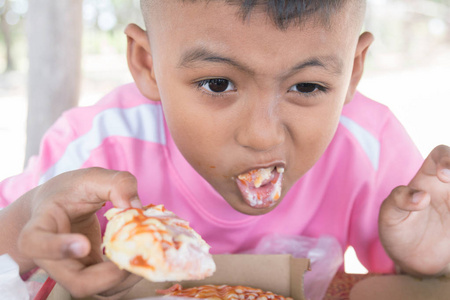 可爱的亚洲小男孩吃零食照片