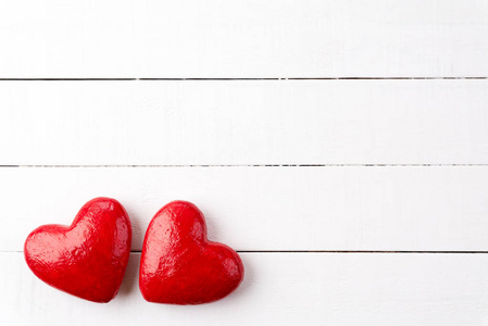 情人节和爱的概念。 白色木板上有两颗手工红心。