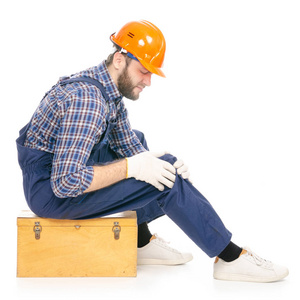 年轻人建设者与工具箱产业工作者安全帽痛苦腿