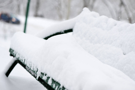 冬天，城市公园里的长凳上覆盖着雪。