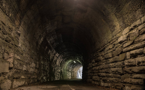 希望的桥梁森林中的隧道入口.由岩石制成的墙照片