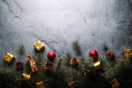 石头背景上的圣诞作文。 圣诞装饰品和带锥的冷杉树枝。 平躺顶视复印空间