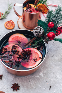 覆盖葡萄酒热饮与柑橘苹果石榴和香料铝砂锅与老式圣诞装饰