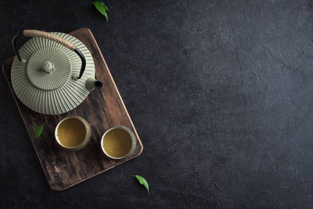 黑色茶具茶壶和茶杯在黑色背景复制空间.