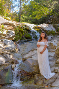 夏天在瀑布附近穿裙子的孕妇