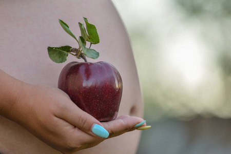 s belly and red apple, isolated on white. Front view of young pr