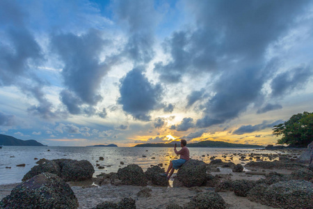 日出海面上一个人在岩石上自拍图片