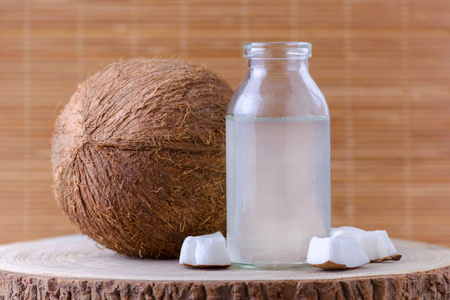 有机椰子水在玻璃瓶和椰子在自然背景