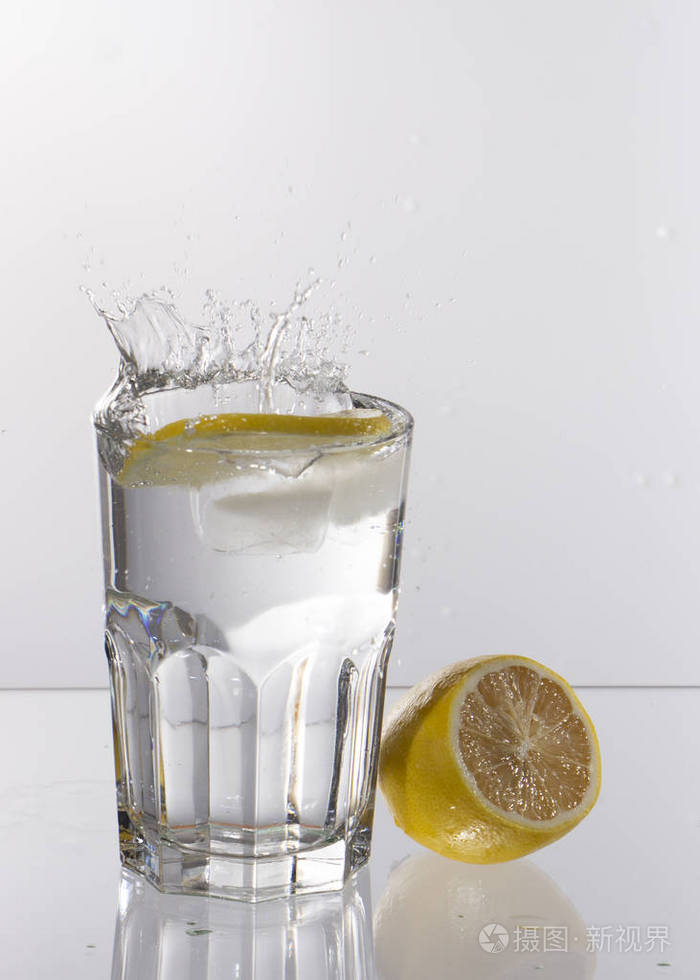 在有泼水的浅色背景上喝一杯柠檬水