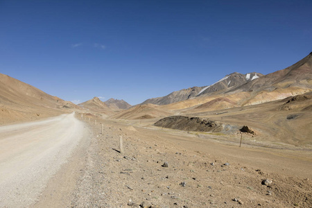 塔吉克斯坦帕米尔山AKBaital Pass地区的沙漠景观和道路