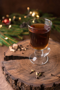 一杯覆盖着酒的冷杉树树枝上的圣诞装饰品放在木桌上。 圣诞节新年假期概念。 复制空间。