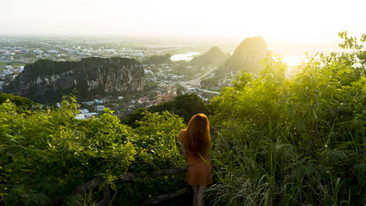 上,看着夕阳下的大南城和越南的朱尼尔西亚和山脉的风景旅行概念照片