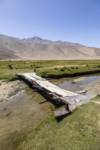 塔吉克斯坦帕米尔山上的一条小河上的老桥