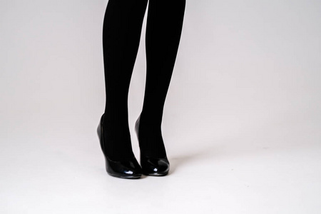 s feet in black stockings or tights, black highheeled shoes 