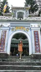 红色头发的旅行女孩正在大理石山上旅行，住在山顶上，看着夕阳下的大南城和越南的朱尼尔西亚和山脉的风景旅行概念