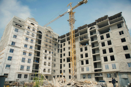 房建施工建设一栋多层住宅楼.黄色起重机背景上的施工.