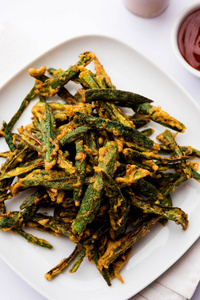 kurkuribhindi或脆脆的ladyfinger或秋葵油炸食谱,用番茄酱和热茶盛在